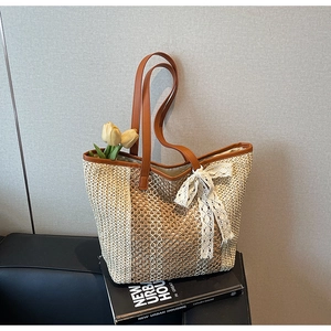 Détail d'un sac cabas tressé avec nœud en dentelle sur fond de livre minimaliste