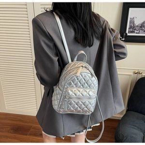 Macro shot of a silver quilted mini backpack with sparkling rhinestones and metallic finish