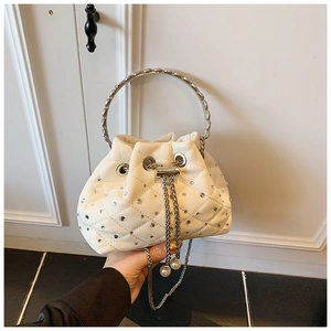 Detailed view of white quilted bucket bag with rhinestones and pearl drawstring tassels