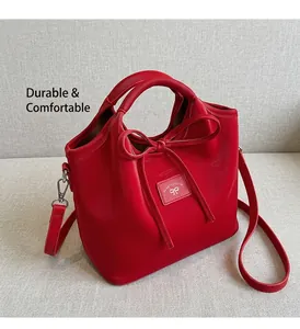 Detail of red matte leather tote bag featuring a bow tie and stylish top handles