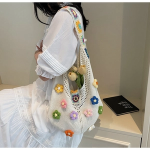 Detail of bohemian white crochet shoulder bag with colorful 3D floral accents and wide strap