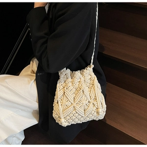 Détail du sac seau tissé main crème avec motifs géométriques et fermeture par cordon