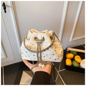 Detail of off-white quilted bucket bag with shimmering rhinestones and pearl drawstring