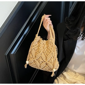 Détail du sac seau macramé artisanal avec fermeture à cordon, pompons et perles en bois