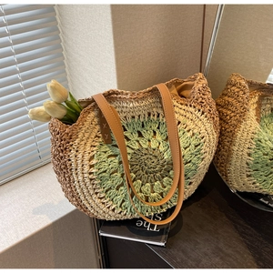 Macro detail of multicolored hollow straw tote with leather strap and woven sunburst pattern