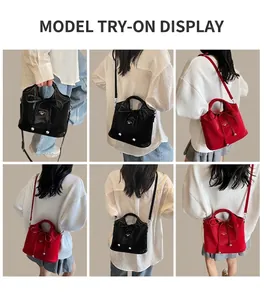 Detail view of red and black glossy bucket bags with bow decor and silver hardware