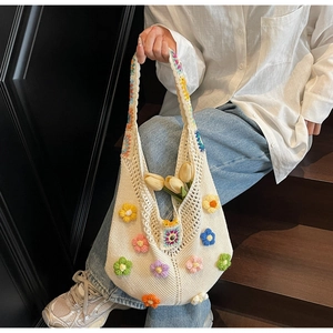 Detailed knit texture of a cream crochet tote bag featuring vibrant 3D floral accents