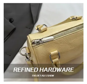 Close-up of light yellow Boston bag showing wrinkled leather texture and silver hardware