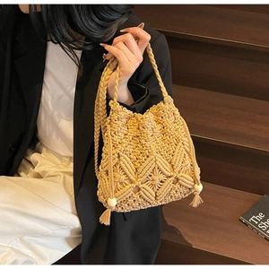 Détail du tissage artisanal à motif de losanges avec pompons et perles de fermeture