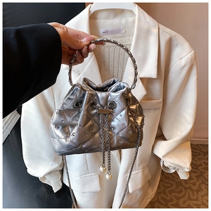 Close-up of silver quilted bucket bag with rhinestone details and pearl drawstrings