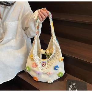 Detail of white knit beach tote featuring colorful 3D crochet flowers and vibrant patterns