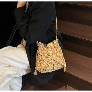 Détail du sac bandoulière en macramé bohème avec pompons et accents de perles en bois
