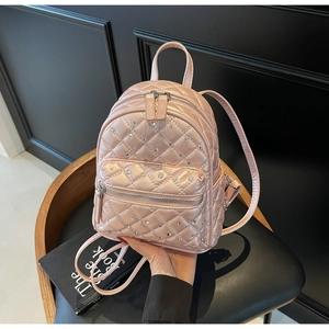 Macro detail of mini quilted backpack in pink with sparkling rhinestone embellishments