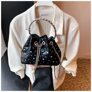 Detail of black quilted bucket bag with rhinestones, pearl drawstring, and metal handle