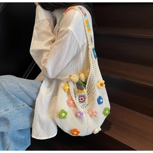 Detailed knit texture of white crochet tote bag with colorful 3D floral embroidery