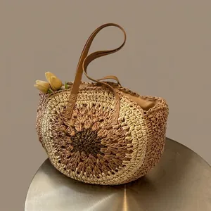 Detail of sunflower pattern straw tote bag with brown leather straps and tulip decor
