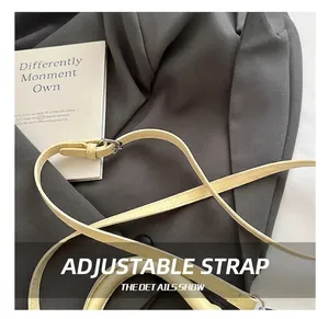 Detail of adjustable beige leather shoulder strap with polished silver buckle on bag