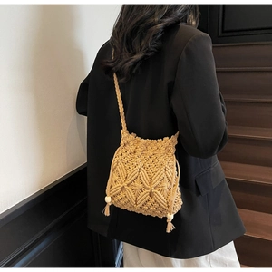 Détail du sac seau en paille tissé à la main avec glands à franges et perles en bois