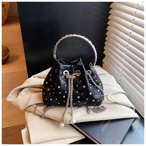 Detail of black quilted bucket bag with rhinestones, silver ring handle and pearl charms