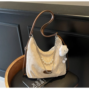 Detail of cream hobo bag with jacquard floral texture and elegant pearl chain strap