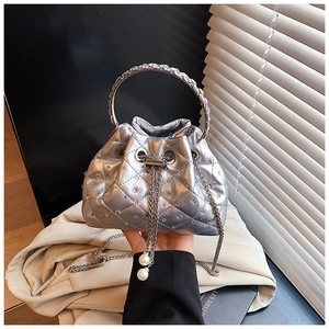 Close-up of silver quilted bucket bag with rhinestone accents and pearl drawstring detail