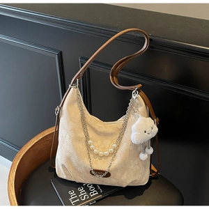 Detail of floral jacquard beige crossbody bag with brown leather trim and pearl chain