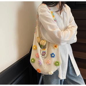 Detailed close-up of handmade crochet tote bag featuring 3D colorful knit floral patterns