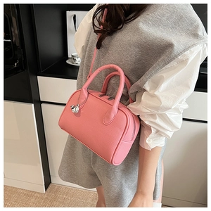 Detail of pink Boston handbag showing lychee pattern leather and animal pendant charm