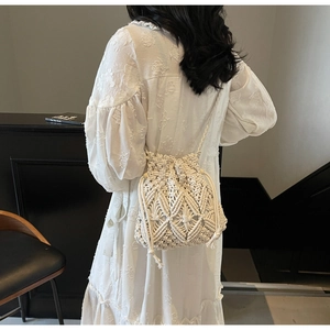 Détail du sac seau en macramé crème avec motifs tressés complexes et pampilles à franges