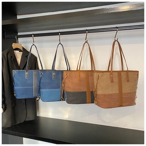Detailed display of four color-block denim tote bags on a modern boutique display rack