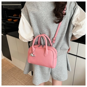 Pink lychee texture crossbody bag with adjustable strap and silver dolphin charm