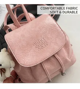 Detailed view of pink PU leather bucket backpack with drawstring and plush bear charm
