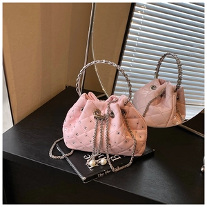 Close-up of pink quilted bucket bag with pearl drawstring and silver metal handle