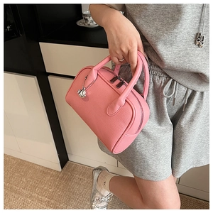Close-up of pink lychee pattern leather bowling bag with round metal ball pendant
