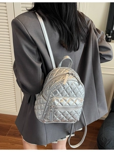 Silver quilted rhinestone mini backpack with metallic finish shown on a model