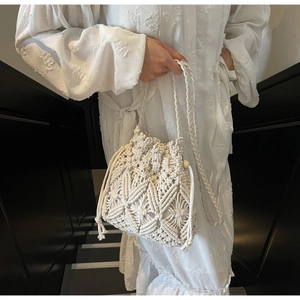 Vue détaillée du sac seau en macramé blanc avec motifs géométriques et perles en bois