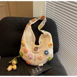 Close-up of hand-knitted bohemian tote bag with colorful 3D floral crochet details