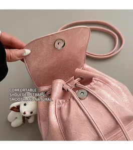 Detail of pink pleated leather bucket bag featuring silver magnetic clasp and drawstring