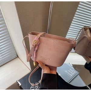 Detailed macro view of pink crocodile pattern bucket bag with premium gold buckle