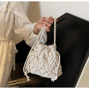 Détail du sac seau en macramé blanc avec motifs tissés à la main et fermeture à cordon