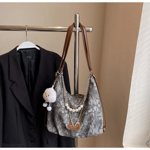 Detail of gray floral canvas tote with pearl chain, leather straps and cloud charm