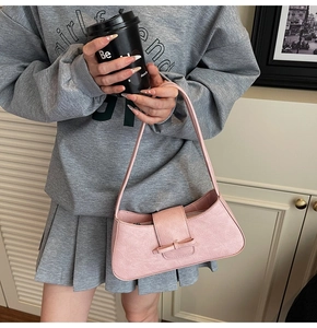 Macro detail of pink wrinkled leather shoulder bag featuring a decorative leather bow