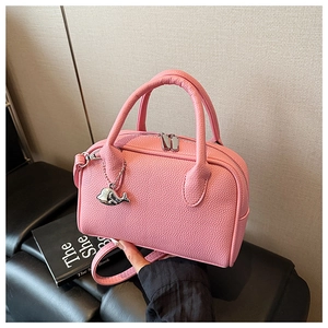 Close-up of pink bowling bag with pebble texture and cute silver whale charm