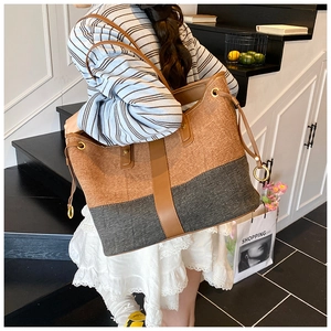 Retro denim tote bag featuring contrast textures with leather strap shown on shoulder