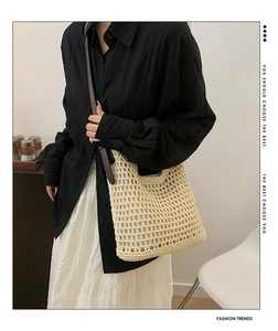 Detail of cream crochet shoulder bag featuring large mesh weave and brown leather strap