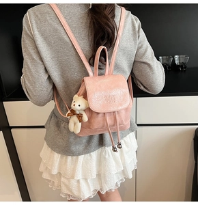 Pink mini backpack with pleated leather texture and a cute white plush bear charm