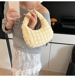 Detail of light yellow quilted bubble texture fabric on a soft hobo cloud shoulder bag
