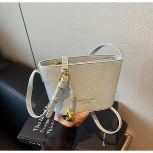 Detail of light blue wave-pattern leather bucket bag with gold hardware and brand logo