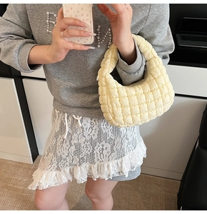 Fashionable quilted yellow cloud bag shown as a crossbody shoulder bag in mirror selfie