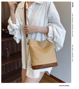Close-up of beige woven bucket bag with dark brown leather base and adjustable silver buckle